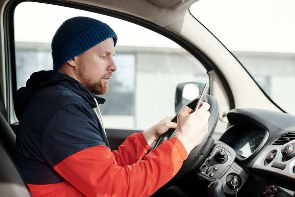 Driver using a smartphone behind the wheel – example of negligence in car accidents due to distracted driving.