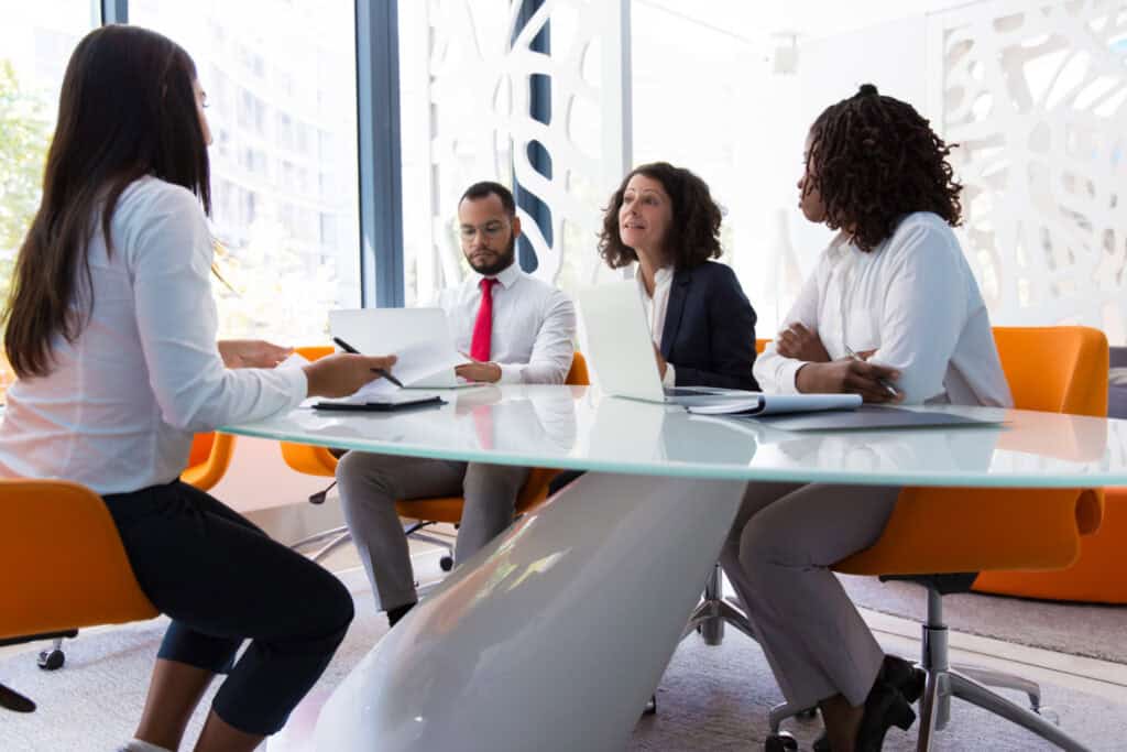 Group of professionals in a meeting room discussing documents and arbitration strategy