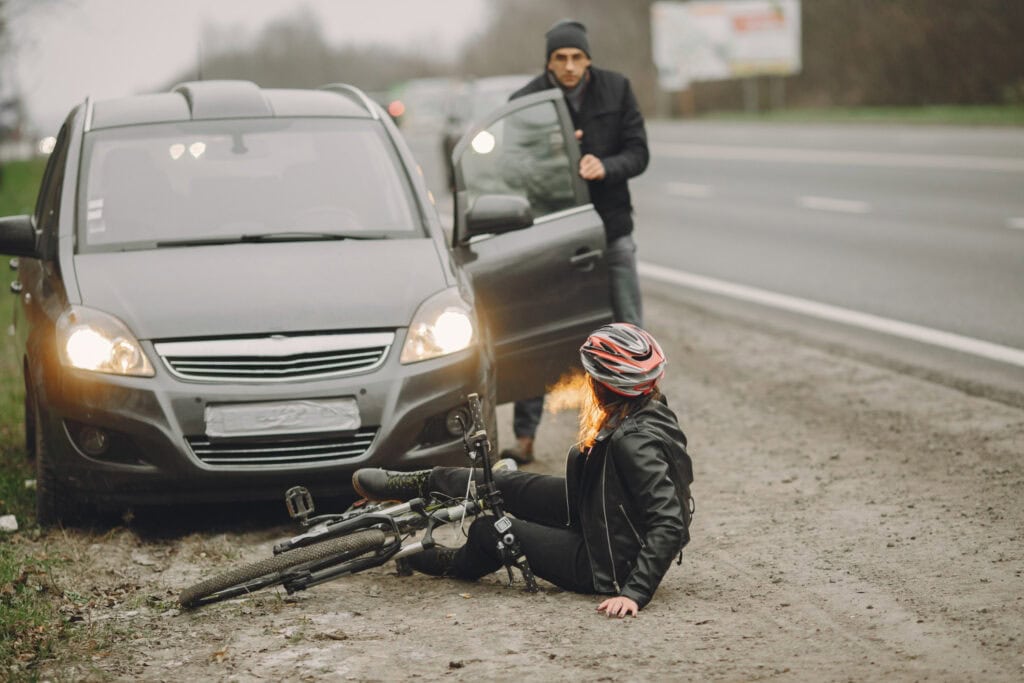 Cyclist injured in car accident as driver exits vehicle on the roadside