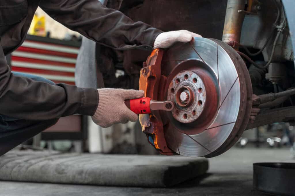 Mechanic repairing faulty brake system involved in NHTSA recall.
