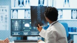 Doctor reviewing an X-ray image and medical scans as evidence for a personal injury claim.