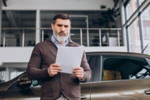 Driver reviewing vehicle documents under California Lemon Law AB 1755 (2025)